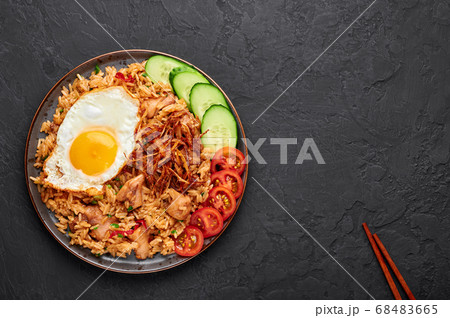 Nasi Goreng - Indonesian Chicken Fried Rice on black plate on slate table top Nasi Goreng - Indonesian Chicken Fried Rice on black plate on slate table top 68483665