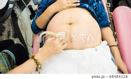 Smiling pregnant women ultrasound test with her 68484128