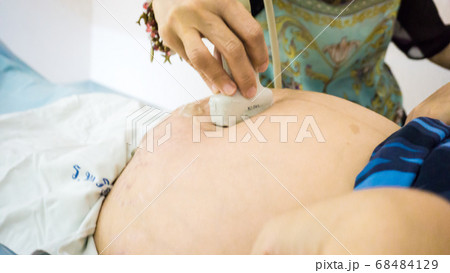 Smiling pregnant women ultrasound test with her 68484129