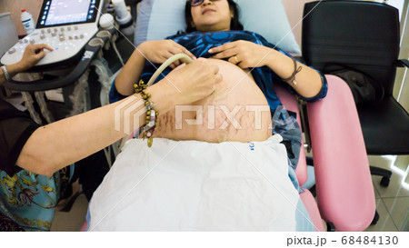 Smiling pregnant women ultrasound test with her Smiling pregnant women ultrasound test with her 68484130