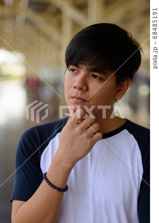 Young handsome Asian tourist man at the railway station Young handsome Asian tourist man at the railway station 68485191