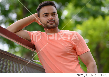 Young handsome bearded Indian man at the park 68486157