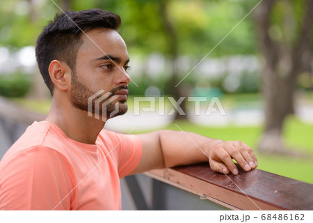 Young handsome bearded Indian man at the park 68486162