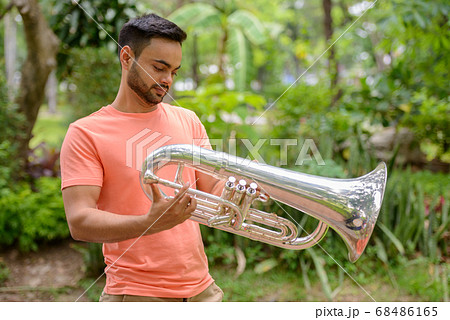 Young handsome bearded Indian man at the park Young handsome bearded Indian man at the park 68486165