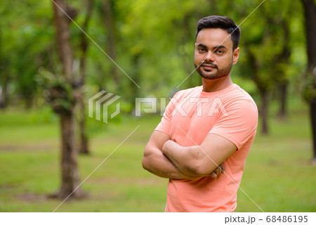 Young handsome bearded Indian man at the park 68486195