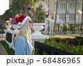 Girl in a red Christmas hat next to the swimming pool with blue water. Holiday concept. 68486965