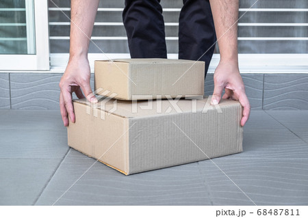 Man's hand holding boxes at the front door to Man's hand holding boxes at the front door to 68487811
