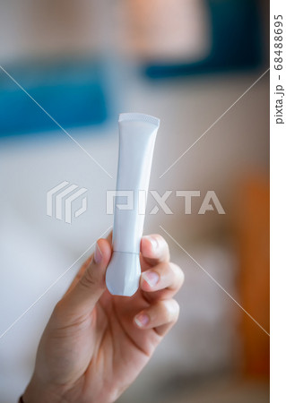 Hand with cosmetics bottle. Hand holding plastic bottle.  68488695