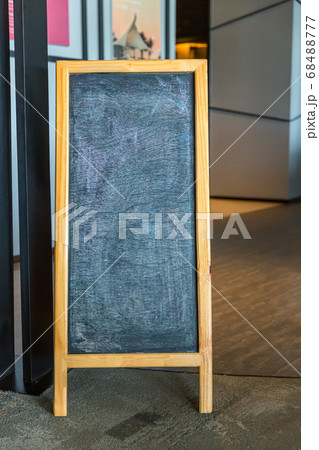 Wooden rustic blackboard in front of restaurant entrance 68488777