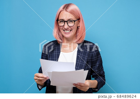 Young business woman with pink hair is analyzing business plan Young business woman with pink hair is analyzing business plan 68489624