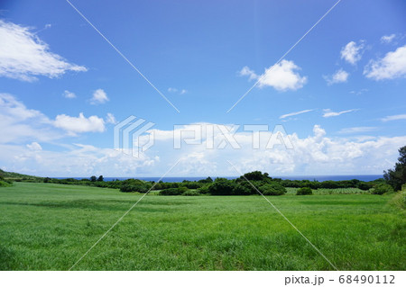 リゾート風景 海と牧草地と山の稜線の写真素材