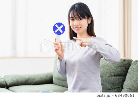 リビングのソファでNGのプラカードを持つ若い女性 リビングのソファでNGのプラカードを持つ若い女性 68490661