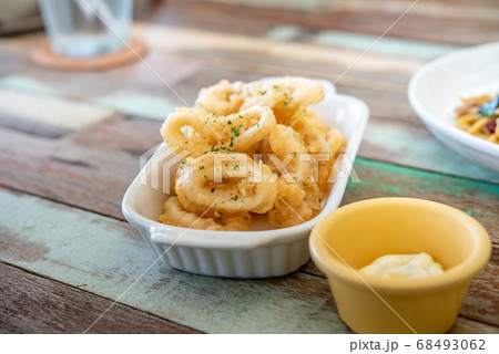 Fried squid with garlic, crispy batter, Asian street food on a wooden floor. Photos jpg 68493062