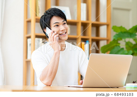 テレワークで電話する若い男性 テレワークで電話する若い男性 68493103