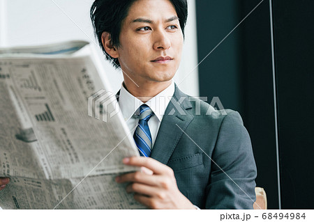 新聞を読むビジネスマンの写真素材