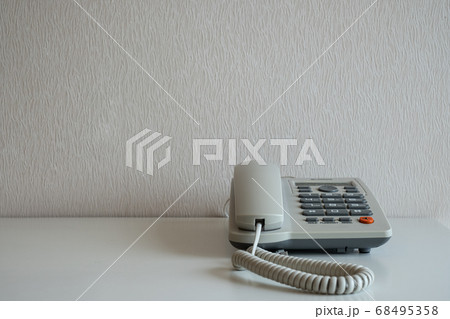 Telephone on the desk at gray wall background Telephone on the desk at gray wall background 68495358