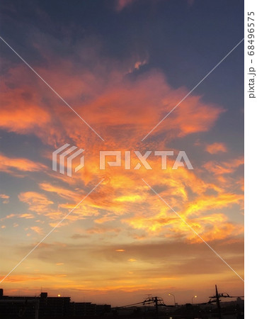 ネイビーの空と夕暮れのオレンジ色の雲グラデーションの空がある風景の写真素材