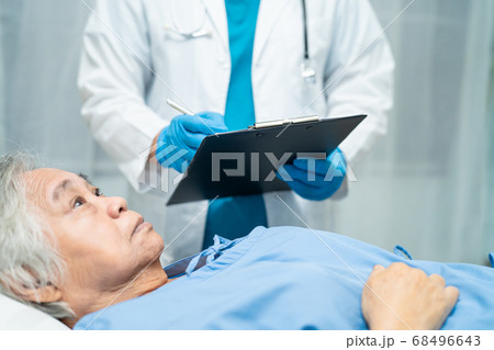 Asian doctor wearing face shield and PPE suit to 68496643