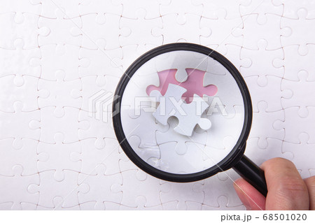 Set of puzzle pieces with magnifying glass 68501020