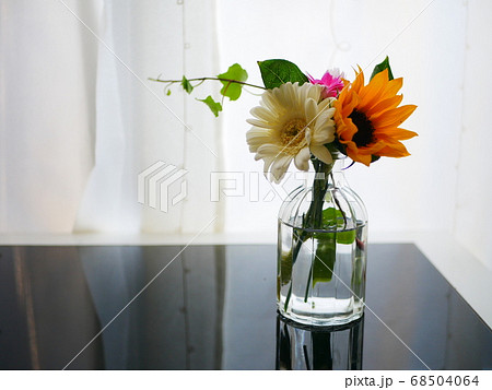 テーブルに飾られているひまわりとガーベラ　花束　お花のサブスク 68504064