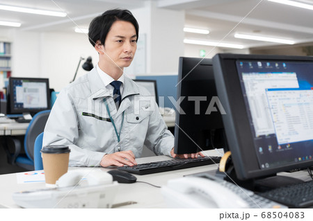 会社でパソコン作業を操作する作業服の若い男性 会社でパソコン作業を操作する作業服の若い男性 68504083