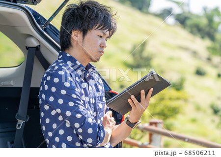 ドライブで休憩中にタブレットをさわる男性 68506211