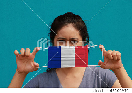 A woman with France flag on hygienic mask in her hand 68506950
