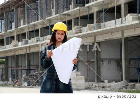 Female civil engineer or architect with yellow helmet. 68507202