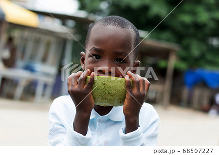 child with a watermelon on the street. 68507227