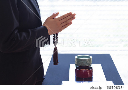 焼香台の前で合掌する喪服の女性 68508384