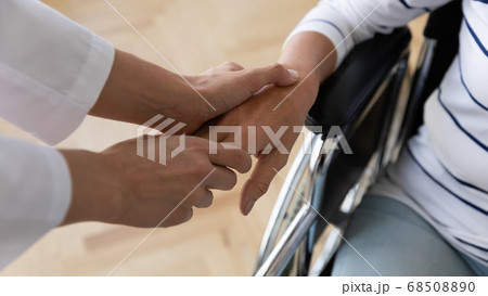 Medical social worker holding hand of disabled old patient. Medical social worker holding hand of disabled old patient. 68508890
