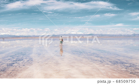 Man alone at endless salt flat Salar de Uyuni. Man silhouette and reflection in the Salar de Uyuni. Man alone at endless salt flat Salar de Uyuni. Man silhouette and reflection in the Salar de Uyuni. 68509750