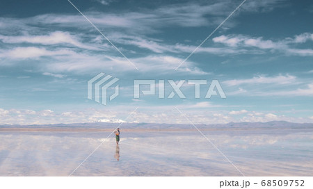 Man alone at endless salt flat Salar de Uyuni. Man silhouette and reflection in the Salar de Uyuni. 68509752