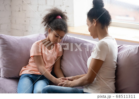 Attentive caring black mother supporting her school age daughter 68511311
