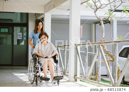 Senior woman in wheelchair Smiling female physiotherapist	 68513874