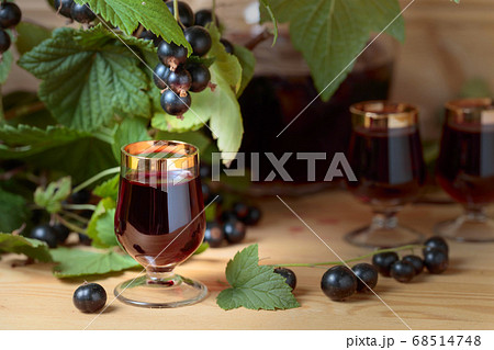 Homemade black currant liqueur and fresh berries . Homemade black currant liqueur and fresh berries . 68514748