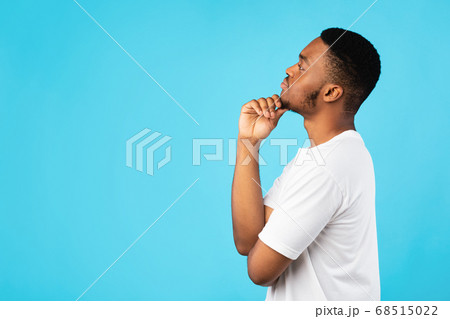 Thoughtful Black Guy Thinking Looking Aside Standing On Blue Background 68515022