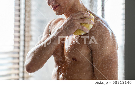 Handsome young man washing his body with puff 68515146