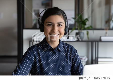 Head shot smiling young indian ethnicity woman in headphones. 68517615