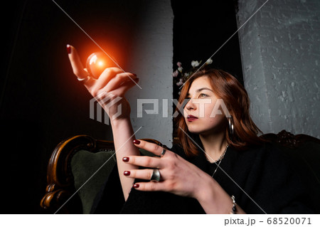 Woman in black suit holding crystal ball Woman in black suit holding crystal ball 68520071