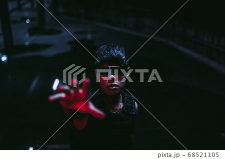 The man pulls his hand up. Cyberpunk style. Night parking. The man pulls his hand up. Cyberpunk style. Night parking. 68521105