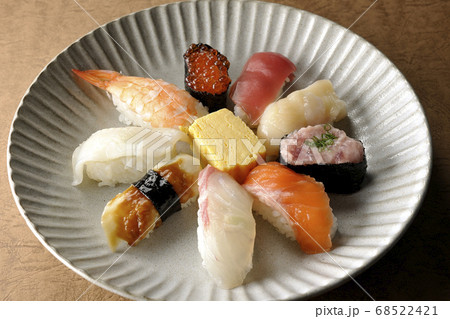 丸い平皿に盛り付けられた鮪、帆立、サーモン、いくら、海老、鯛、イカ、穴子、ネギトロ巻きの握り寿司 丸い平皿に盛り付けられた鮪、帆立、サーモン、いくら、海老、鯛、イカ、穴子、ネギトロ巻きの握り寿司 68522421