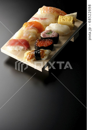 寿司下駄に盛られた鮪、帆立、サーモン、いくら、海老、鯛、イカ、穴子、ネギトロ巻きの握り寿司(黒背景) 68522698
