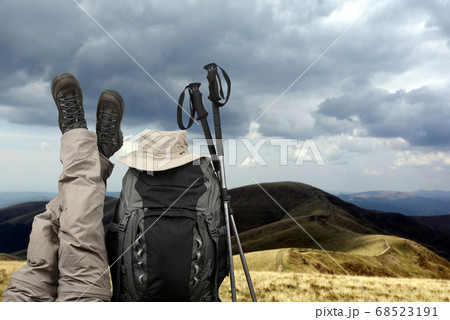 tourist crossed her legs up near a backpack in nature 68523191