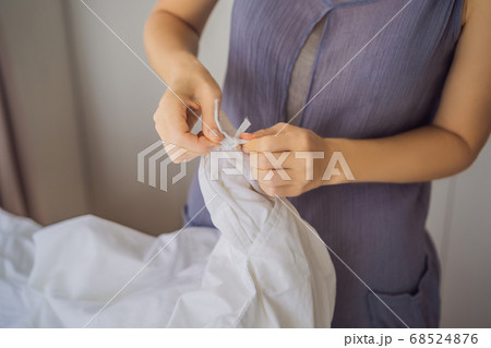 Young Female Housekeeper Changing Bedding In Hotel Room 68524876