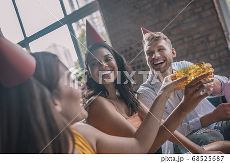 Three smiling friends drinking alcohol during the birthday party 68525687
