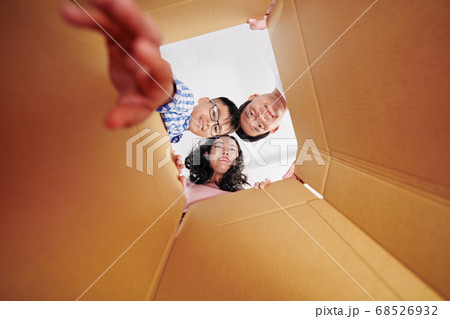 Family looking inside cardboard box 68526932
