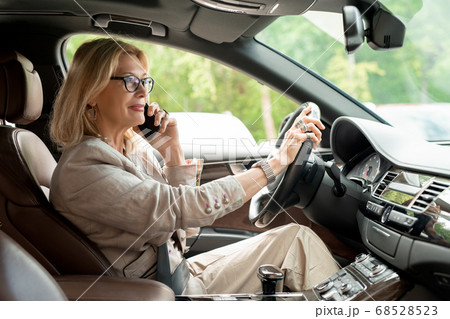 Successful elegant businesswoman in eyeglasses and casualwear holding by steer Successful elegant businesswoman in eyeglasses and casualwear holding by steer 68528523