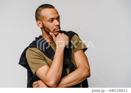 african-american young man in green t-shirt over light grey background with copy space 68529821