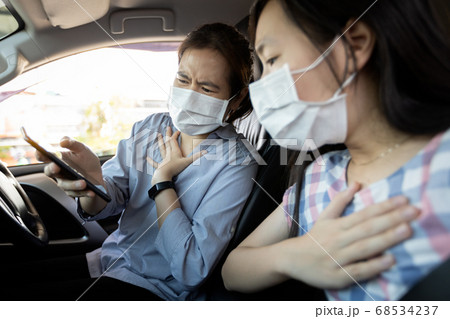 Shocked asian woman read news of the Corona virus on mobile phone,scared of Covid-19 pandemic,child girl watch breaking news about Coronavirus worldwide outbreak,causing daily deaths and infections 68534237